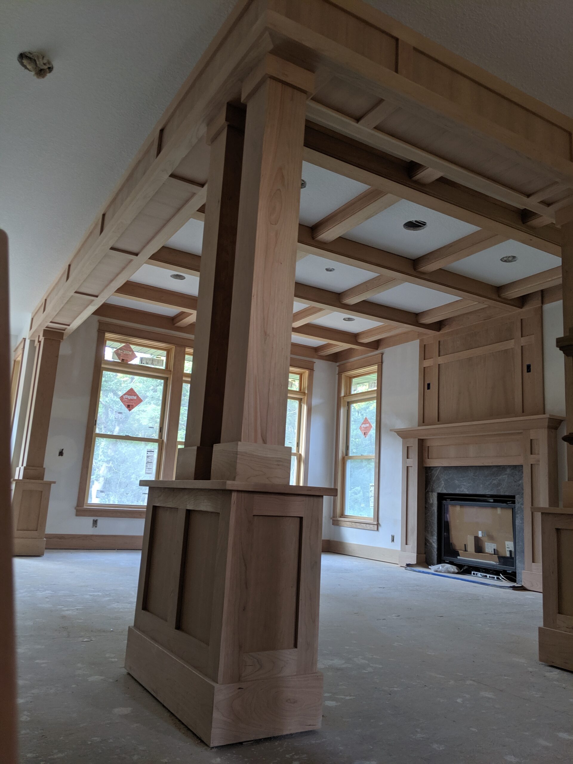 Custom windows, ceiling beams and fireplace surround millwork