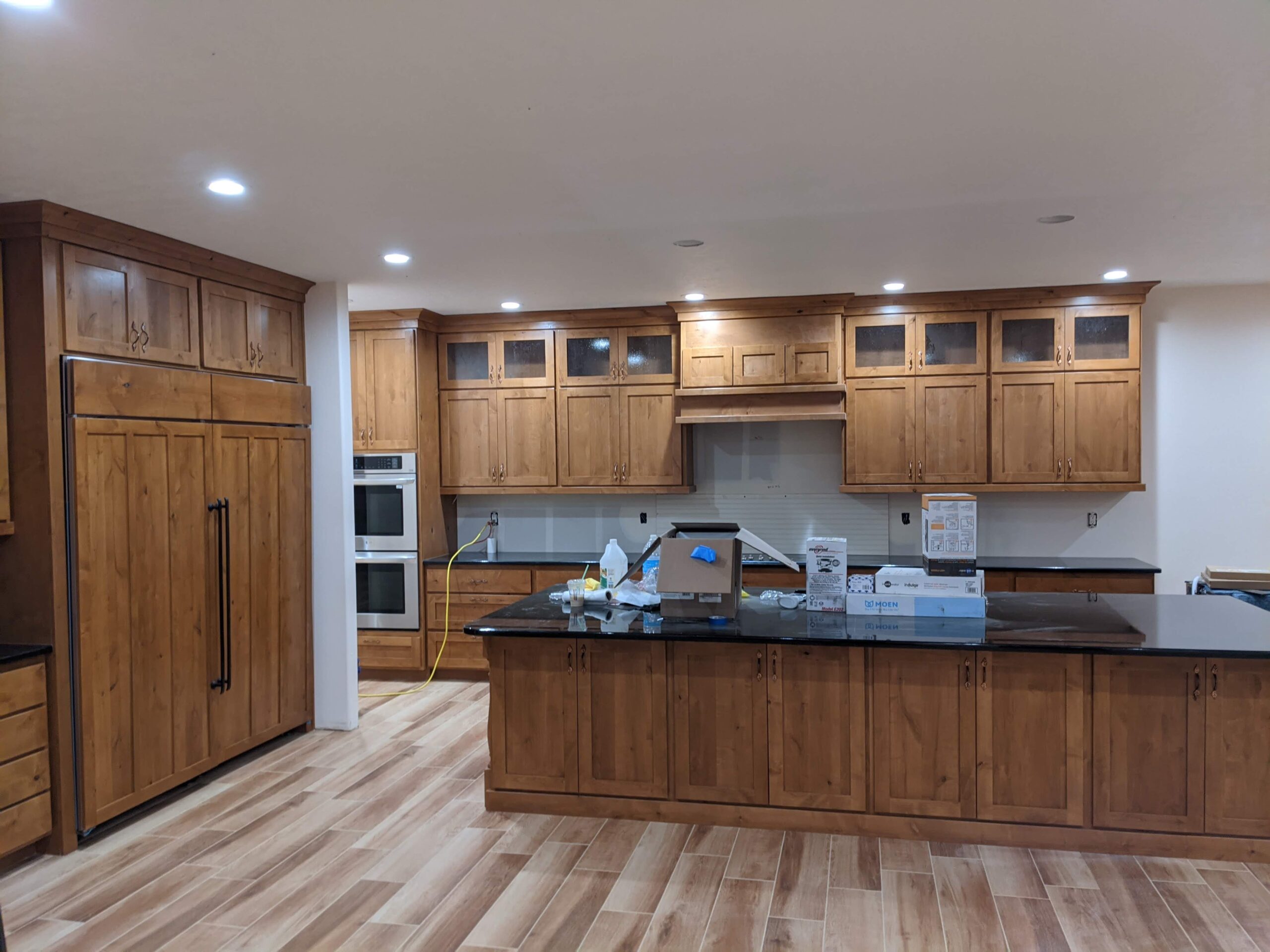 Full kitchen cabinet installation with knotty wood and granite