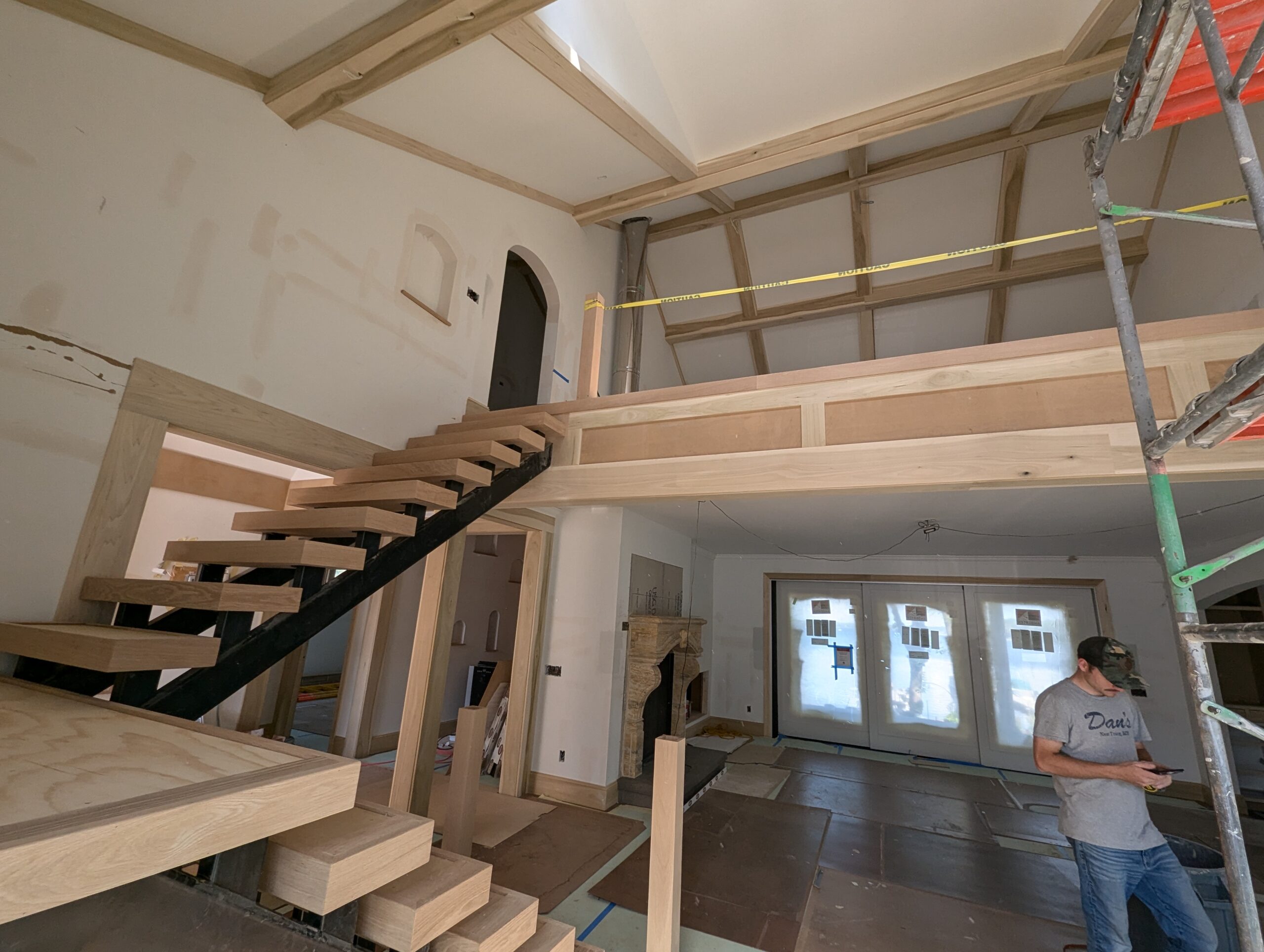 Custom oak floating staircase with ceiling beams and millwork