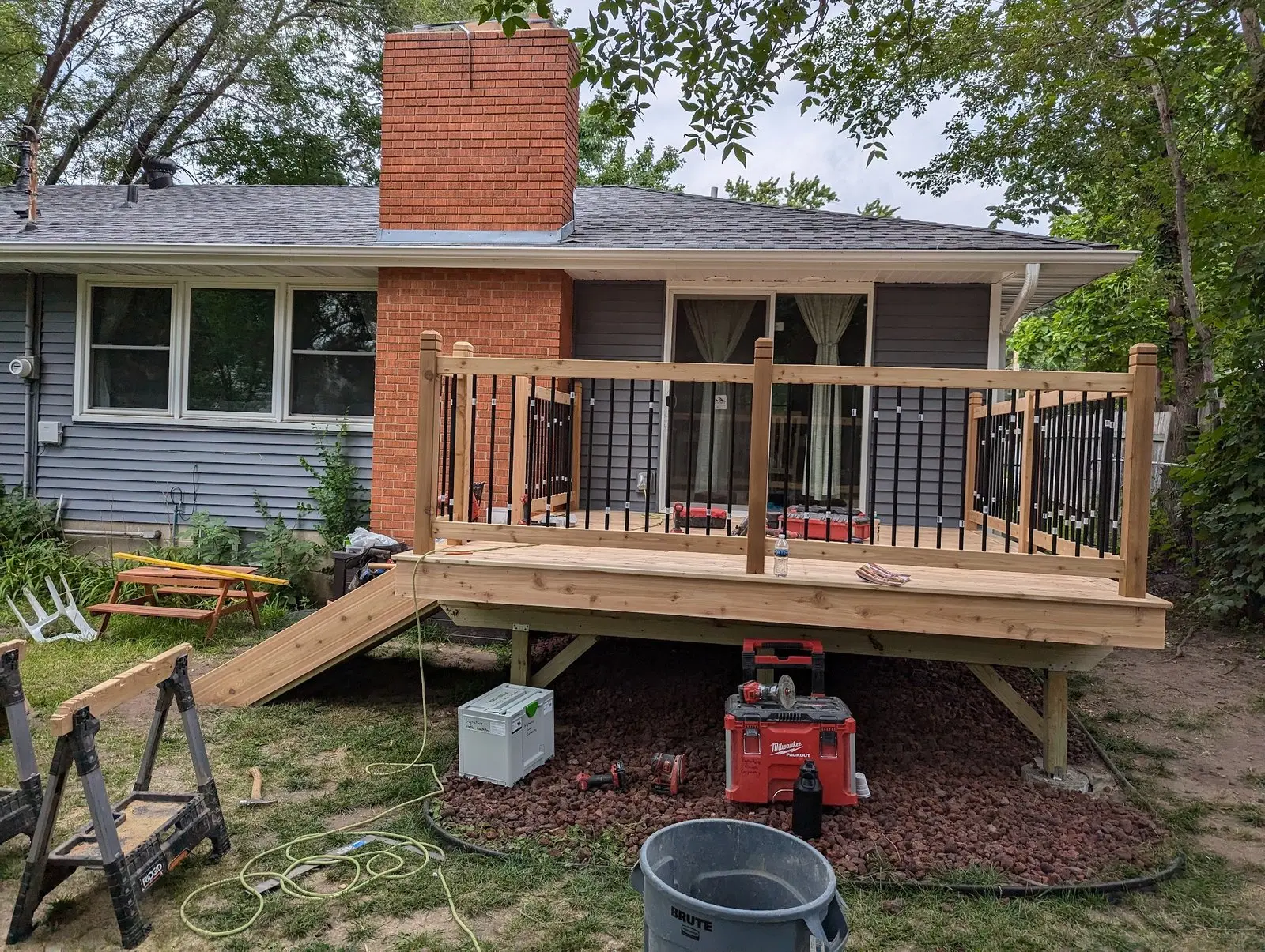 Original project photo of porch framing, stairs, posts, and railing installation
